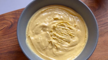 No-bake mango cheesecake jar topped with cream and fresh mango pieces